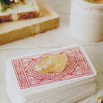 Tarotkartenstapel mit hellem Stein auf einem Tisch