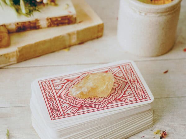 Tarotkartenstapel mit hellem Stein auf einem Tisch