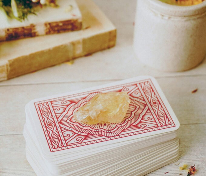 Tarotkartenstapel mit hellem Stein auf einem Tisch