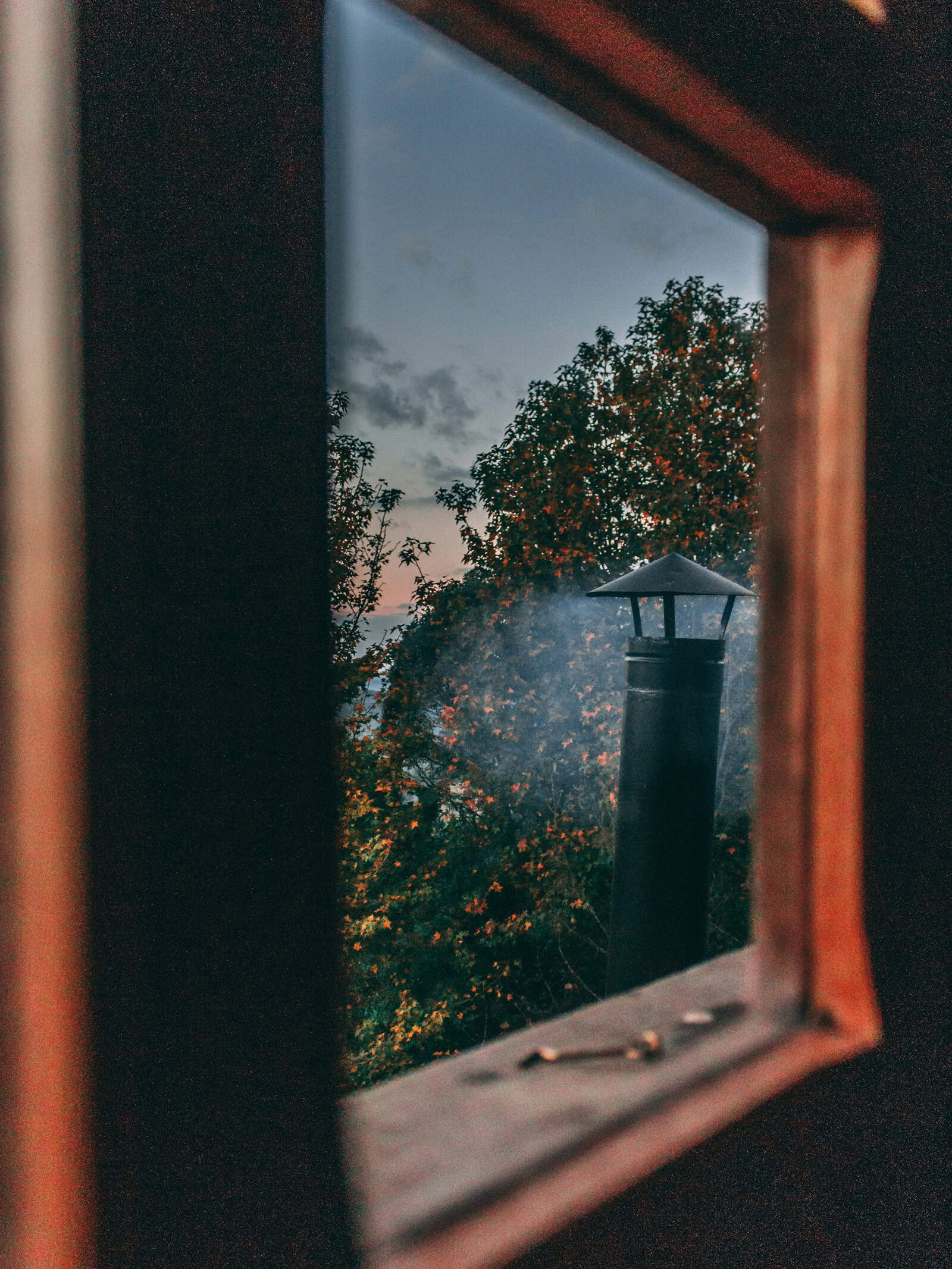 Rauhnächte früher: Rauch zieht an einem Fenster vorbei – Symbol für Schutzrituale und gemeinschaftliche Übergangszeit zwischen den Jahren.