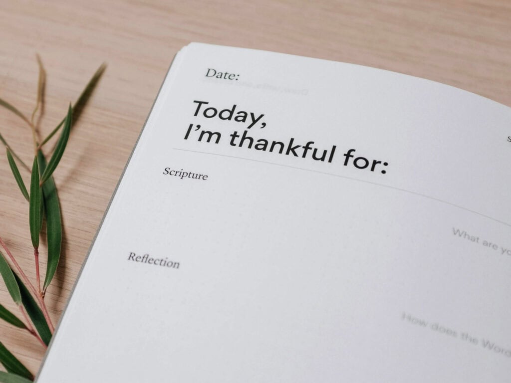 Offenes Journal mit der Seite ‚Today I am thankful for‘, Datum, Schriftstellen, Reflexionsfragen und weiteren Feldern zum Ausfüllen, um Dankbarkeit und Tagesreflexion zu dokumentieren.