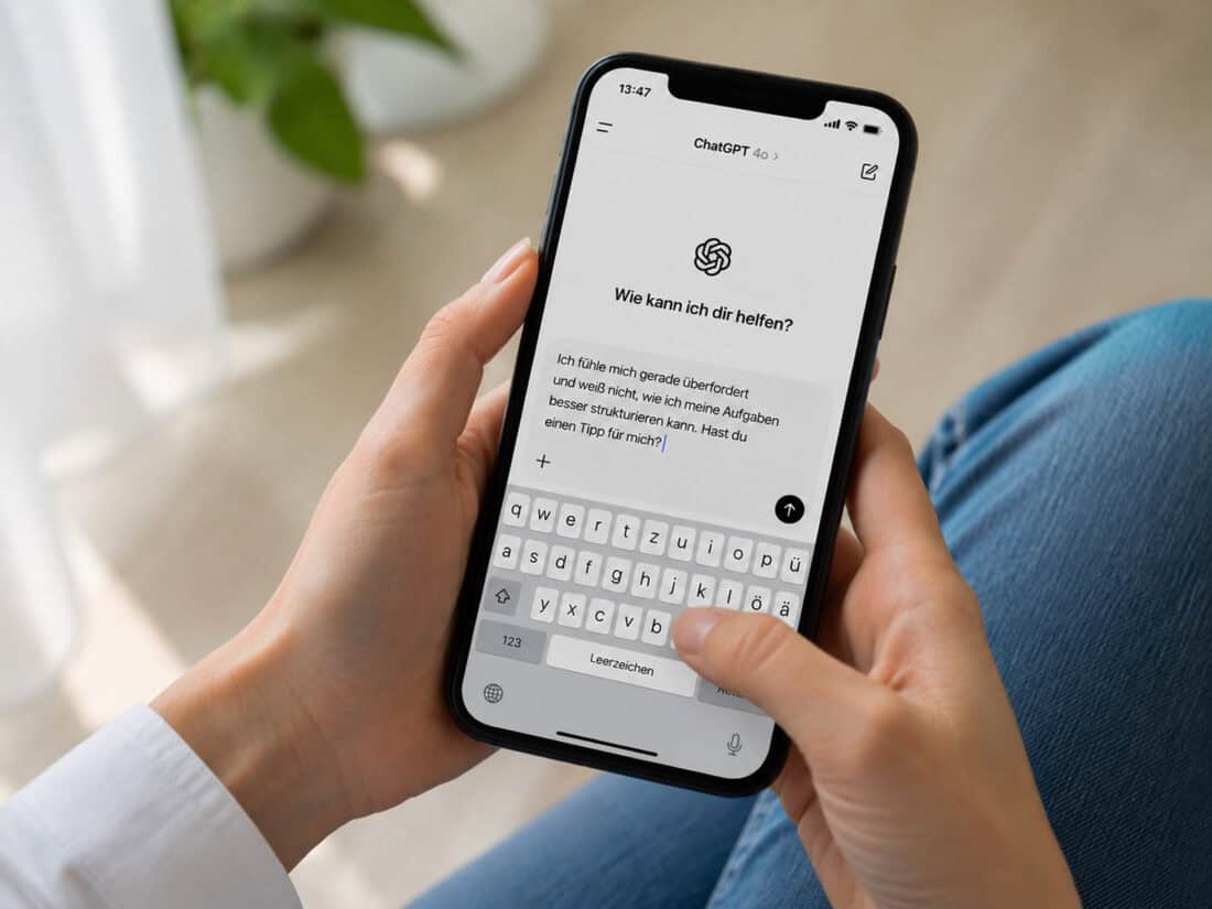 Weibliche Hände halten ein Smartphone mit geöffneter ChatGPT-App und sichtbarer Texteingabe