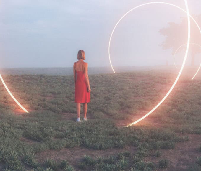 Frau steht in einer nebligen Landschaft vor großen leuchtenden Lichtkreisen - Symbol für Portaltage.