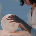 Eine Person hält eine leuchtende Mondkugel in den Händen – Symbolbild für den Artikel über Mondknoten und astrologische Deutung.