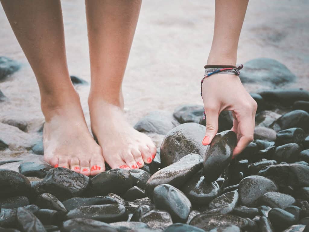 Klassische Spiritualität: Barfuß am Wasser stehen und bewusst einen Stein wahrnehmen