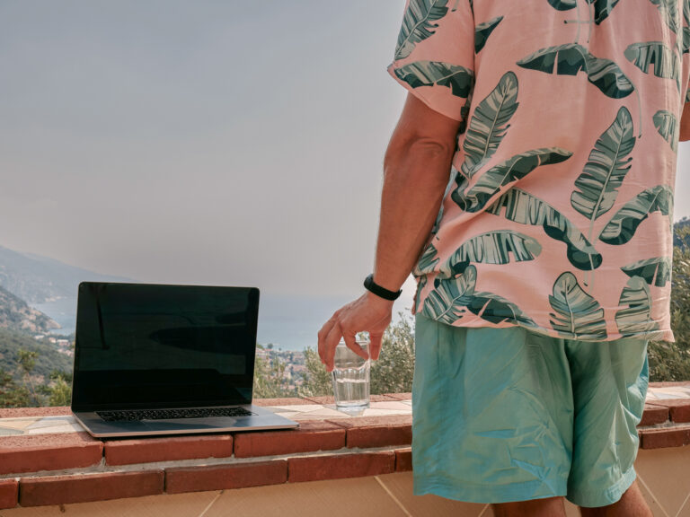 Mann sitzt mit Laptop am Meer, als Symbol für das Versprechen von passivem Einkommen mit Affiliate-Links.