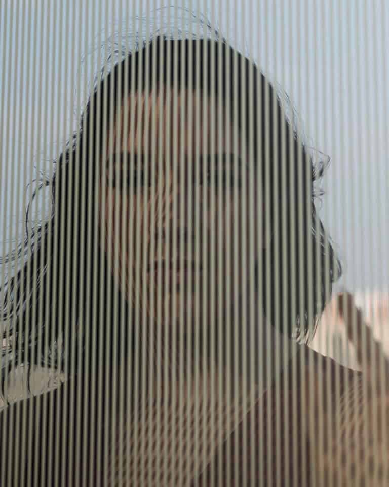 Frau hinter strukturierter Glasscheibe als Symbol für Wahrnehmung und Barnum-Effekt